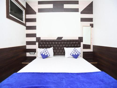 una camera con letto e lenzuola bianche e blu di New Ashi Palace a Varanasi