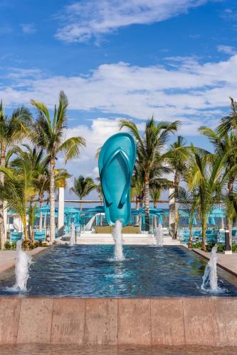 a fountain in a pool with a blue dolphin in the water at Margaritaville Island Reserve Riviera Maya - An Adults Only Karisma All-Inclusive Experience in Puerto Morelos