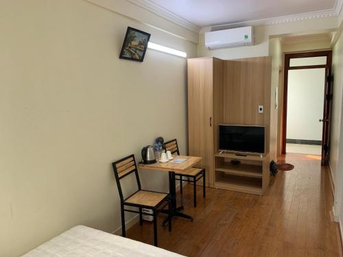 een kamer met een tafel en stoelen en een televisie bij Dong Duong Hotel in Hai Phong