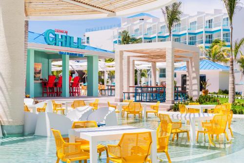 a view of a restaurant with tables and chairs at Margaritaville Island Reserve Riviera Maya - An Adults Only Karisma All-Inclusive Experience in Puerto Morelos