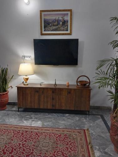 a living room with a flat screen tv on a wall at 1 Kanal Entire House with 4 Bedrooms in Lahore