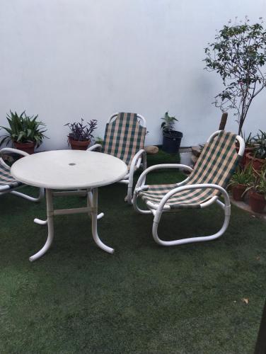 three chairs and a table and a table and chairs at 1 Kanal Entire House with 4 Bedrooms in Lahore
