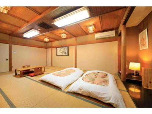 Fujinomiya Green Hotel - Vacation STAY 19020v في فوجينوميا: غرفة فيها سرير وطاولة فيها