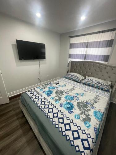 a bedroom with a bed with a tv on the wall at Triple M Lodge Double in Mississauga