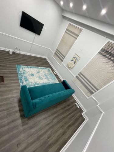 a living room with a blue couch and a tv at Triple M Lodge Double in Mississauga