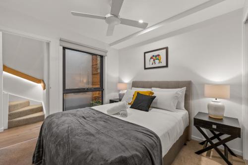 a bedroom with a bed and a desk and a window at StayCentral - Brunswick Central Townhouse in Melbourne