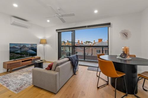 a living room with a couch and a table at StayCentral - Brunswick Central Townhouse in Melbourne