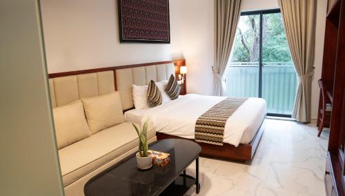 Habitación de hotel con cama y sofá en Marvelinn Siem Reap en Siem Reap