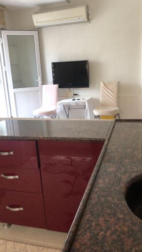 a room with a desk with a tv and chairs at NEŞELİ APART BAHÇE CAFE in Seferihisar