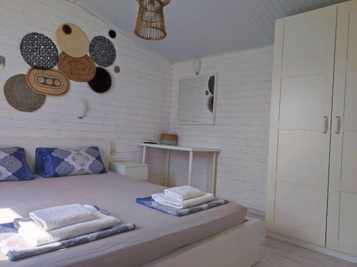 1 dormitorio con 1 cama con toallas en Къщички Морски Светулки, en Sinemorets