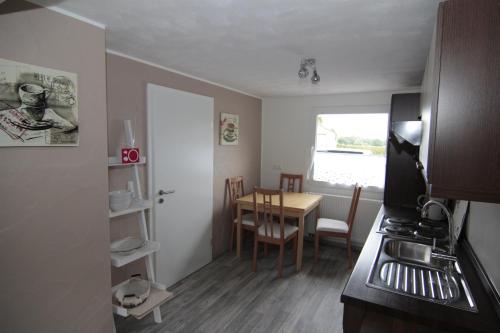 eine Küche und ein Esszimmer mit einem Tisch und einer Tür in der Unterkunft Ferienwohnung Margot in Simmerath