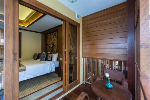 a bedroom with a bed and a table in a room at Wannamas Chiangmai Boutique House in Chiang Mai