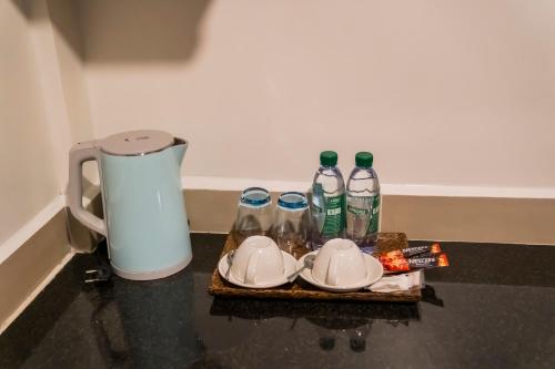 a tray with bottles and plates and a coffee maker at Marvelinn Siem Reap in Siem Reap