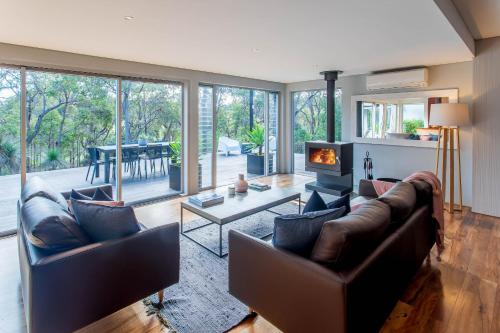 a living room with leather furniture and a fireplace at Mahree I Private Properties in Yallingup