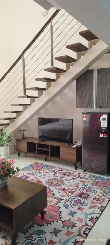 a living room with a television and a large rug at SofiaSuite16, Plaza Azalea, Shah Alam in Shah Alam