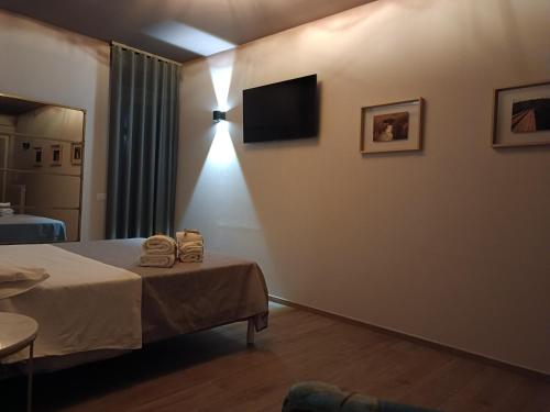 een kamer met een bed en een televisie aan de muur bij SOHO B&B in Fisciano