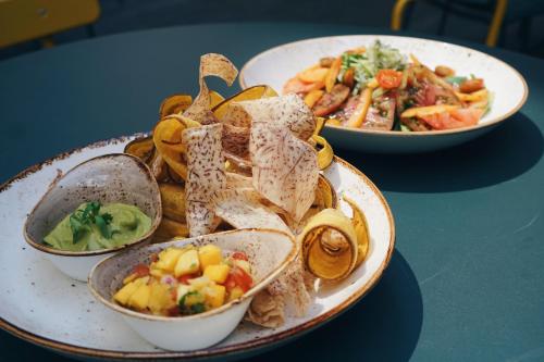 two plates of food on a blue table at Vignette Collection Yours Truly DC by IHG in Washington