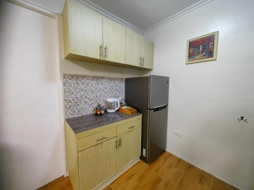 a kitchen with a refrigerator and a counter top at Casa Felicitas 1 - Spacious Cozy 1 Bdr Condo At Seawind Condominium in Davao City