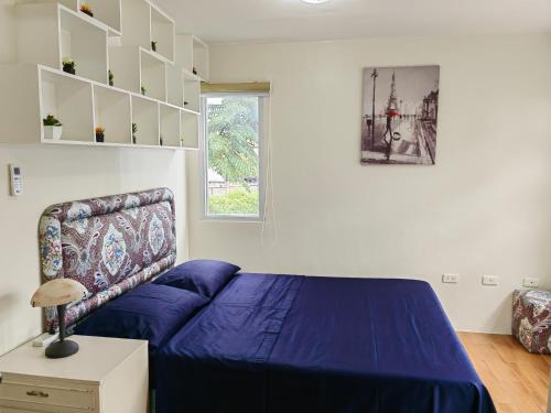 a bedroom with a blue bed and a window at Casa Felicitas 1 - Spacious Cozy 1 Bdr Condo At Seawind Condominium in Davao City