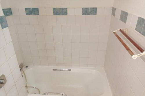 La salle de bains est pourvue d'une baignoire blanche et de toilettes. dans l'établissement Charmant Studio à Sainte Anne -Plage avec Parking, à Sainte-Anne