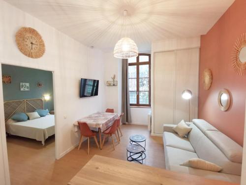 un soggiorno con un divano e un tavolo di LA GABICHE - NOUVEAU T2 FACE AUX THERMES ad Aulus-les-Bains