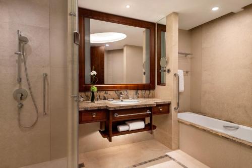 a bathroom with a sink and a tub and a mirror at Shangri-La Nanchang丨Adjacent to Pavilion Prince Teng Prime river view in Nanchang