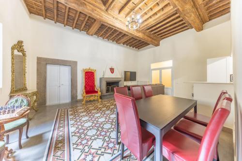 a dining room with a table and red chairs at The House of Thrones in Viterbo
