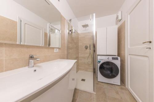 a white bathroom with a washing machine in it at The House of Thrones in Viterbo