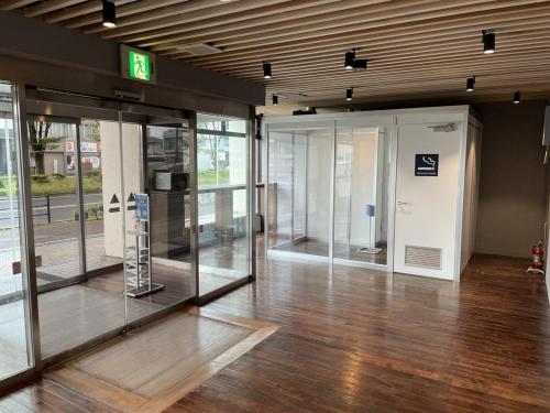an empty lobby with glass doors in a building at Hotel Mayflower Sendai in Sendai