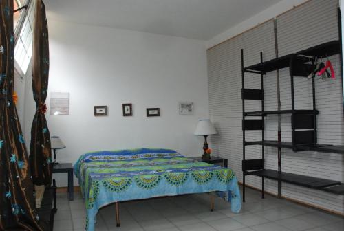 una camera da letto con un letto con una coperta blu sopra di Apartment Circe a Sabaudia