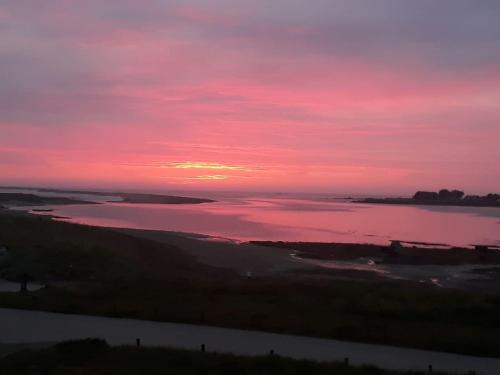 a sunset over a large body of water at Gîte Les Chardons Bleus , les pieds dans l’eau in Pleubian