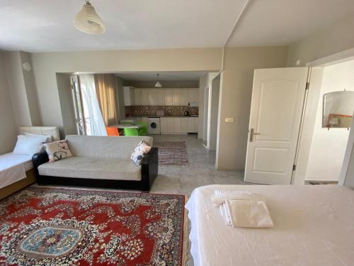 uma sala de estar com duas camas e um sofá em NEŞELİ APART BAHÇE CAFE em Seferihisar