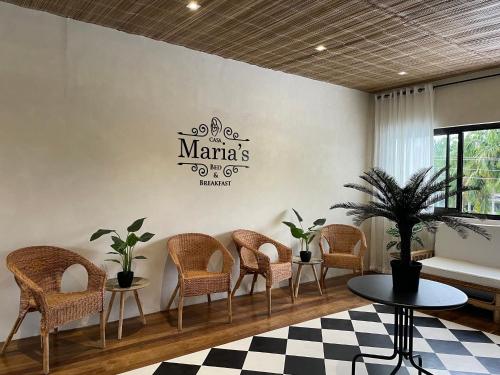 Casa Maria's Bed & Breakfast في Echague: غرفة انتظار وكراسي وعلامة على الحائط