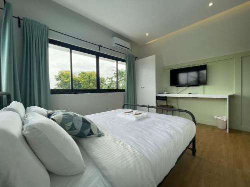 a bedroom with a white bed with a large window at Casa Maria's Bed & Breakfast in Echague