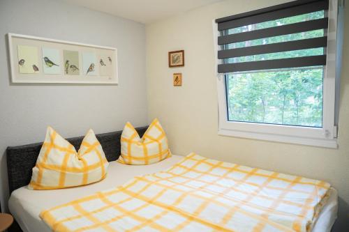 a bedroom with a bed with yellow and white pillows at HausMeise in Heidesee