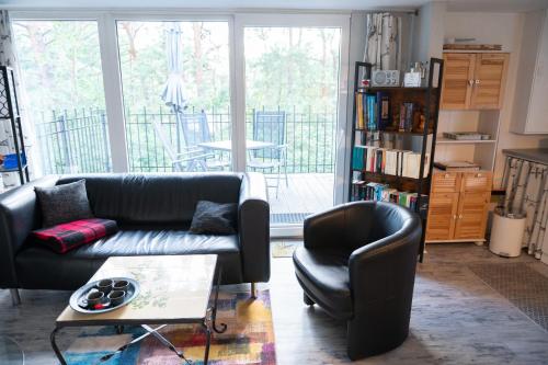 een woonkamer met een bank, een stoel en een tafel bij HausMeise in Heidesee