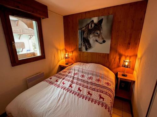 een slaapkamer met een wolvenfoto aan de muur bij Appartement aux portes de Megeve in Praz-sur-Arly