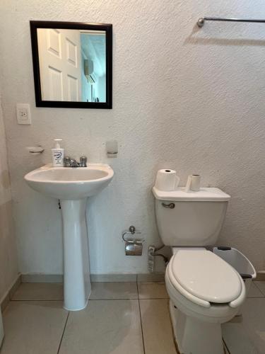 uma casa de banho com um WC branco e um lavatório. em Acapulco Marina Diamante em Acapulco