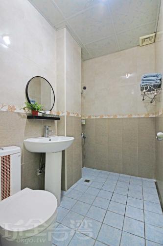 a bathroom with a sink and a toilet and a mirror at 有風小院 in Green Island