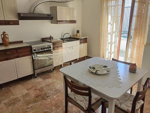 Appartamento Ida vacanza mare في بوليكورو: مطبخ مع طاولة عليها صحن