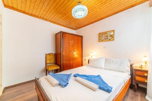 a bedroom with a bed and a wooden ceiling at Captain Spiros House in Lákones