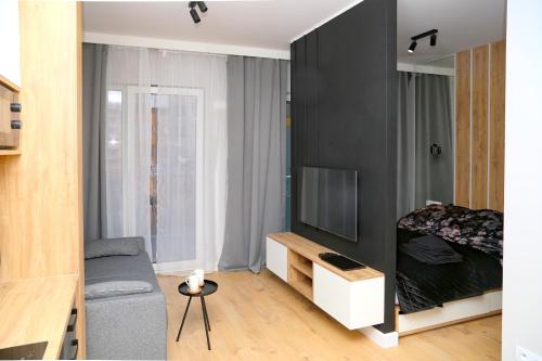 ein kleines Wohnzimmer mit Sofa und TV in der Unterkunft Narwik Comfort Warszawa Bemowo in Warschau
