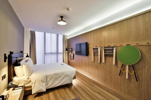 上海市にあるMoxy Shanghai Hongqiao NECCのベッドとテレビが備わるホテルルームです。