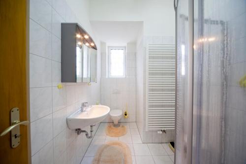 een witte badkamer met een wastafel en een toilet bij Kloster Esthal in Esthal