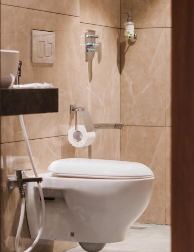 a bathroom with a white toilet and a sink at Treebo Serenity Inn, Koregaon Park in Pune