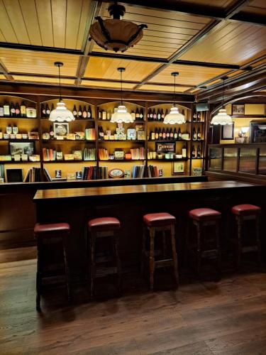 um bar com bancos numa sala com prateleiras em The Coachmans Inn em Roscommon