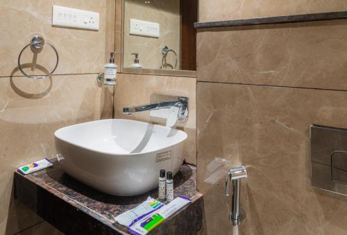 a bathroom with a large white bowl sink on a counter at Treebo Serenity Inn, Koregaon Park in Pune