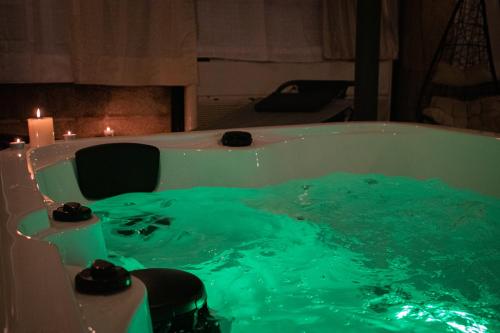 a bath tub filled with green water next to a candle at Hotel San Giuseppe in Gerace