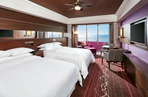 a hotel room with two beds and a flat screen tv at Sheraton Grande Tokyo Bay Hotel in Urayasu
