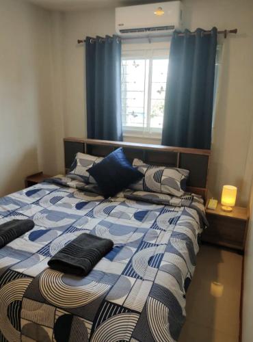 sypialnia z 2 łóżkami pojedynczymi i niebieskimi zasłonami w obiekcie cross 4 w Phuket